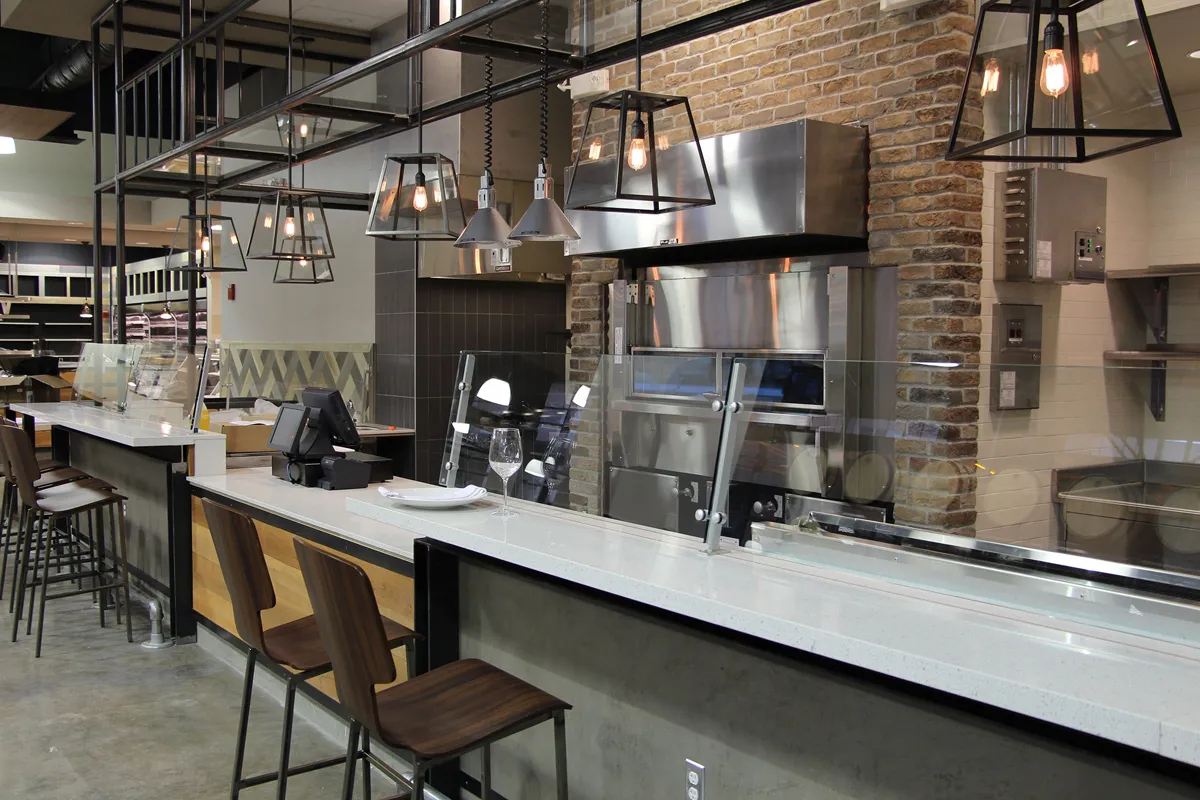 Open kitchen or food service area with industrial-style design and bar seating