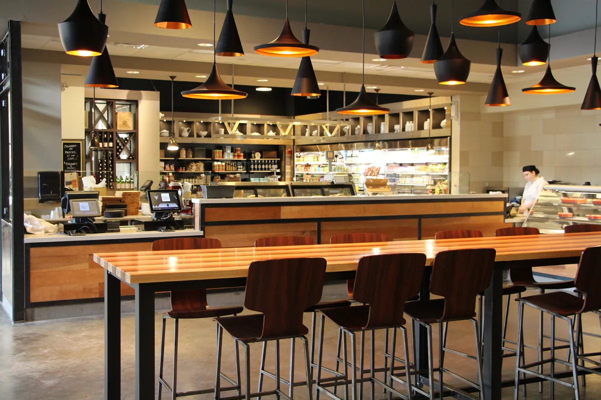 Modern bar or restaurant interior with high-top seating and backlit shelving