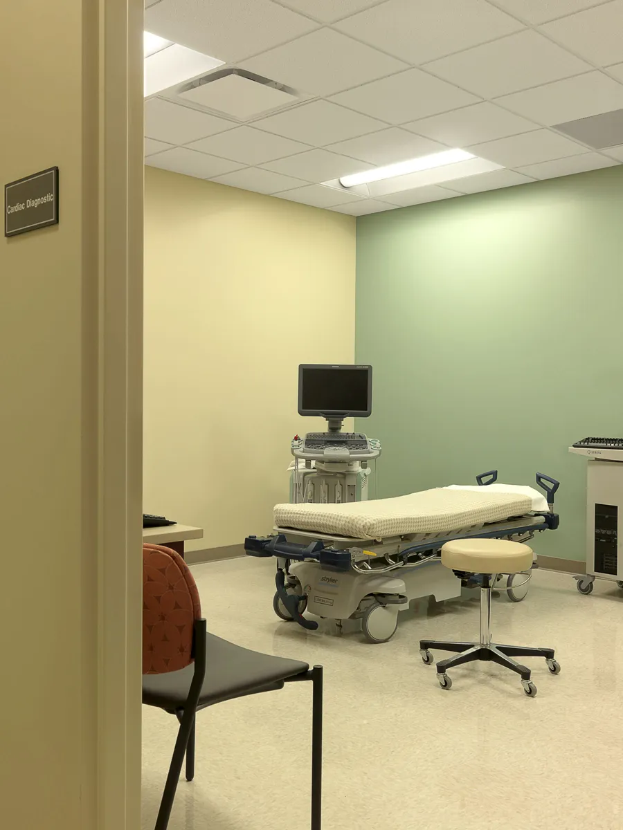 Medical exam room with adjustable treatment table and blue accent wall