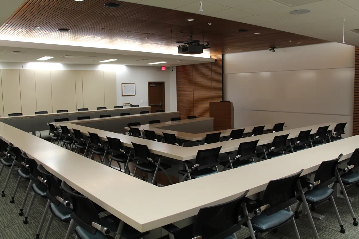 Tiered lecture hall or classroom with rows of seats and presentation screen