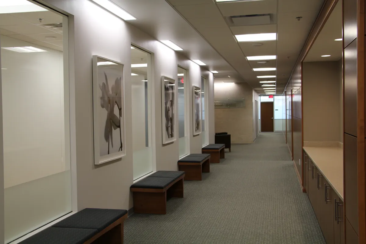 Long clinical corridor with overhead lighting and neutral finishes