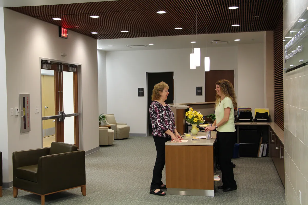 Modern waiting room with dark seating and pendant lighting