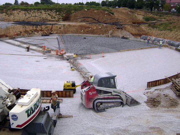 construction equipment laying gravel on water treatment site