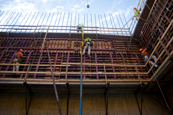 workers setting foundation elements wearing safety gear