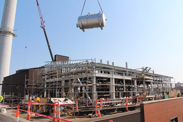 crane lifting large power plant tanks into position
