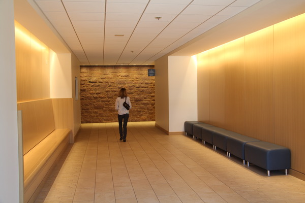 woman walking down well-lit hallway