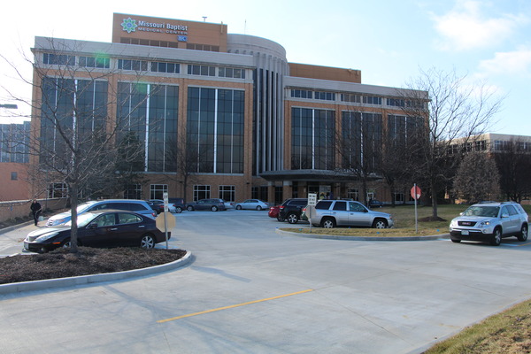 Exterior view of a multi-story hospital with parking lot