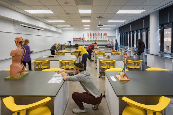 Open medical classroom with yellow seating and exposed ceiling