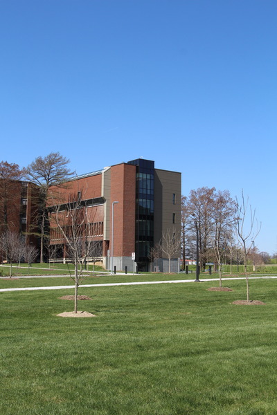 Exterior view of a red brick academic or institutional building with green lawn