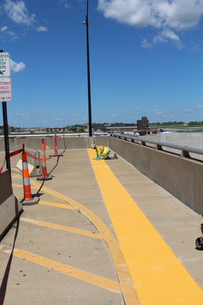 Newly poured concrete pathway with construction equipment in background