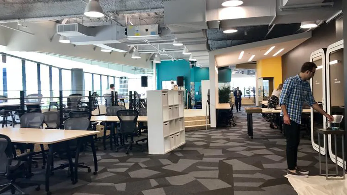 Modern open office or co-working space with colorful furniture and pendant lighting
