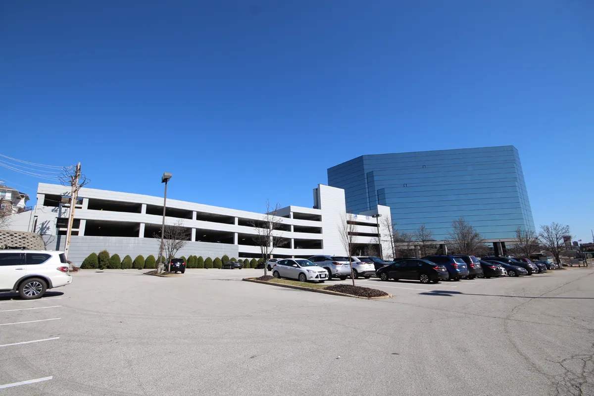 parking garage with glass building under blue sky