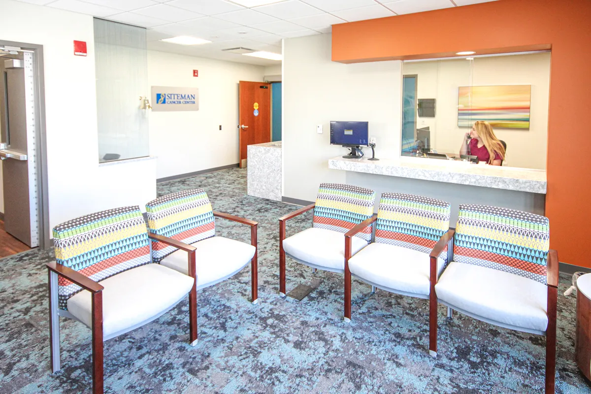 Healthcare reception desk with warm wood tones and recessed lighting