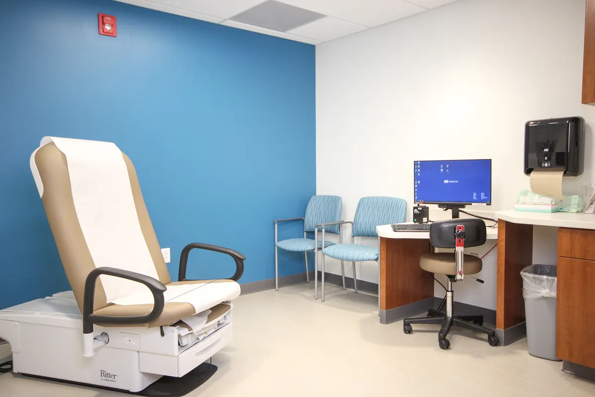 Medical exam or procedure room with reclining chair and blue accent wall