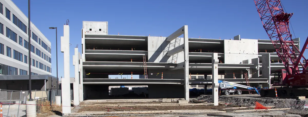 Exterior of a parking garage with crane visible during construction