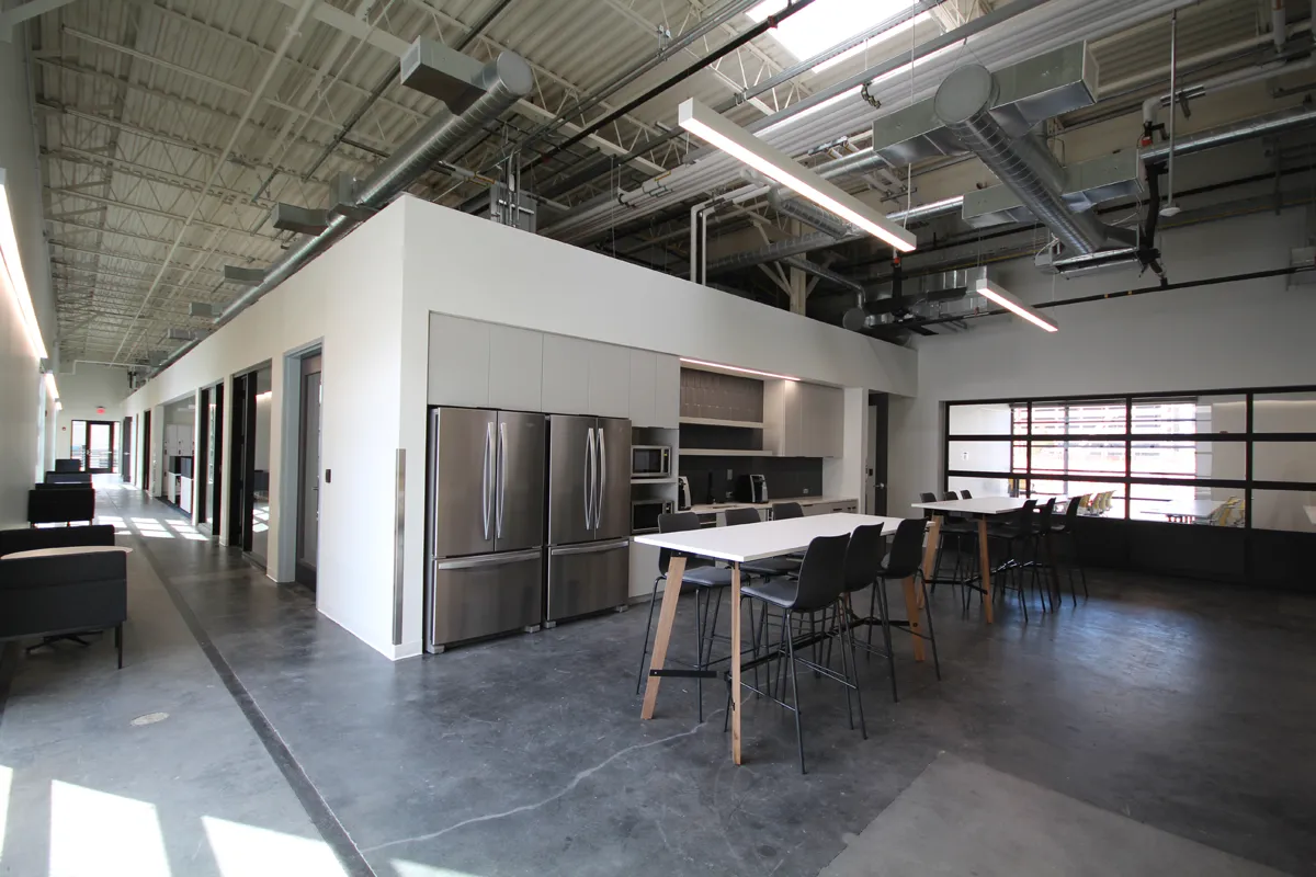 Open loft-style office or event space with exposed concrete ceiling and large windows
