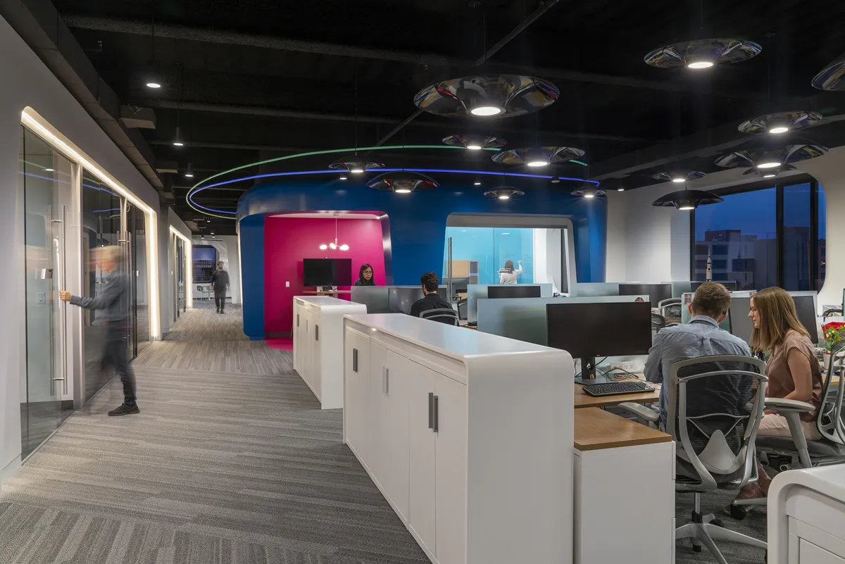 Modern office space with cubical desks and bright accent lighting