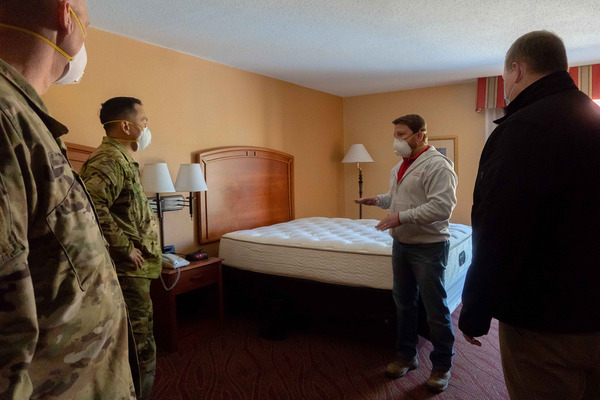 Workers reviewing plans inside a hotel room under renovation