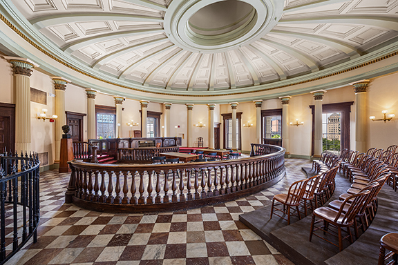 Historic interior rotunda with checkered marble floor and ornate balcony