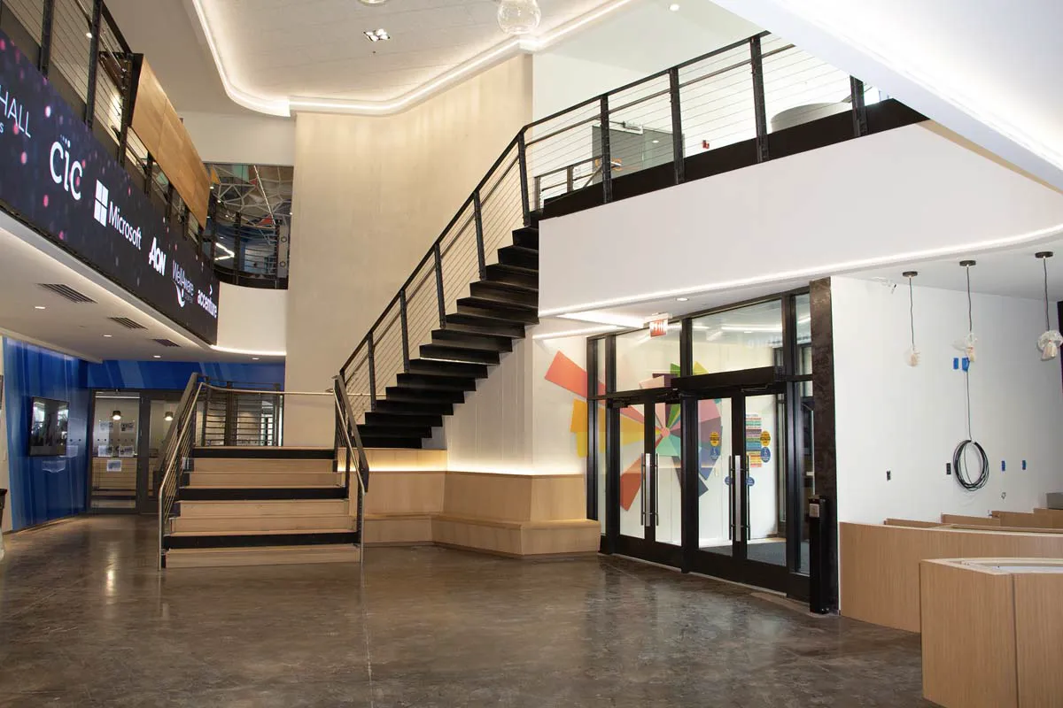 Interior staircase with steel railings and large windows in a modern building