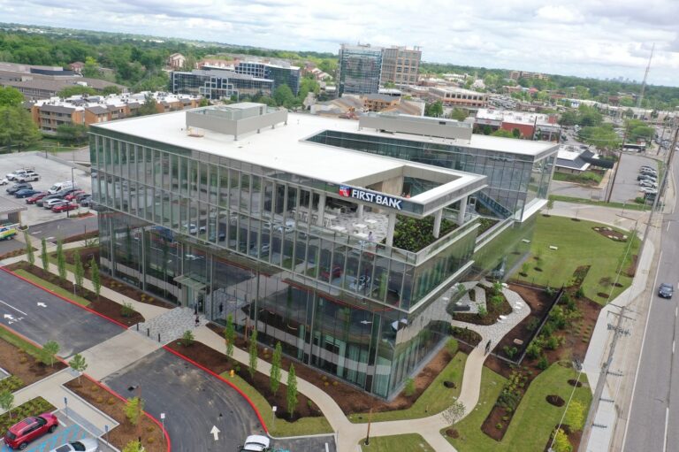 Aerial view of glass building with surrounding green landscape