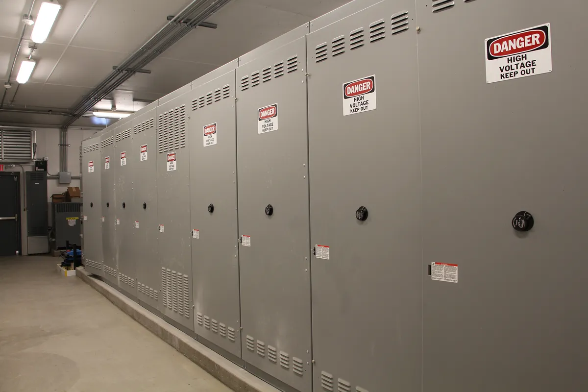 Rows of electrical panels or server racks in a mechanical or data room