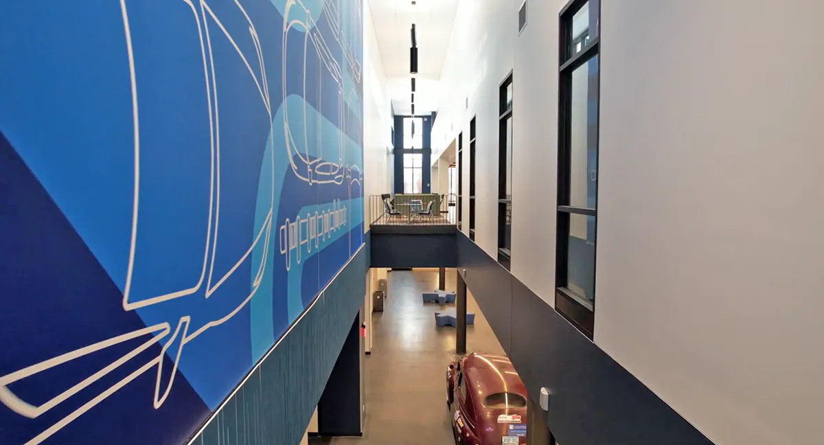 Modern corridor with blue accent wall graphics and overhead lighting