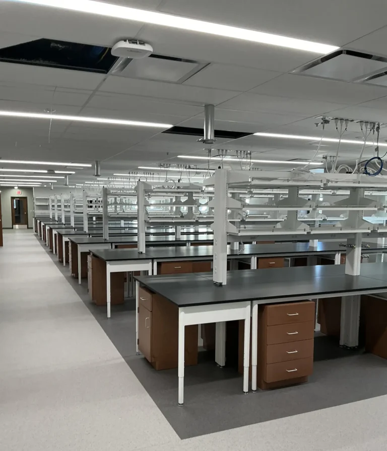 Modern laboratory with dark countertops, workbenches, and overhead lighting