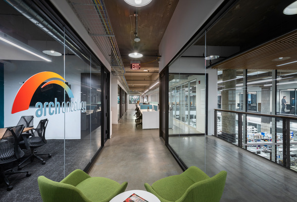 Modern open office with exposed ceiling, colorful mural, and collaborative seating