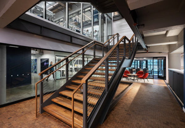 Interior staircase with wood treads and industrial-style railings in a modern building