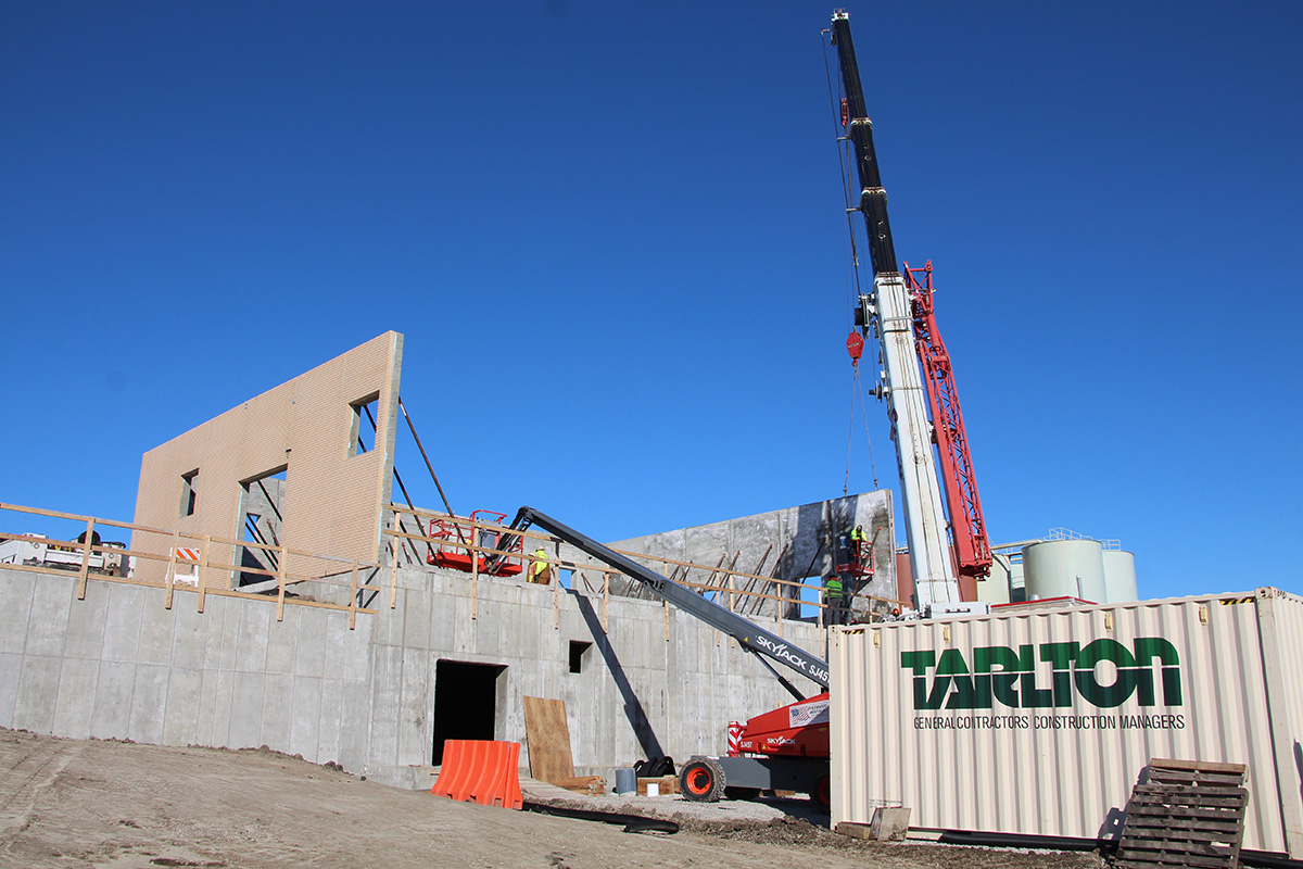Construction site with a rocket or tower structure visible against a blue sky — Tarlton Corporation project