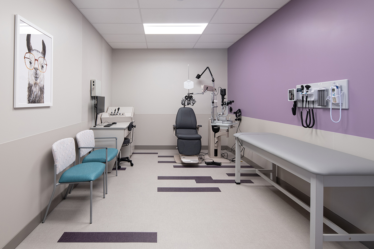 Bright clinical room with light purple walls and medical equipment