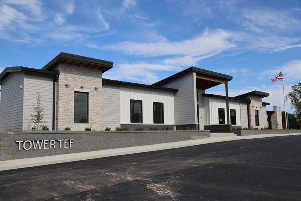 Exterior of a newly completed building with dark metal roof and white walls