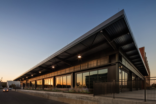 Exterior of a modern building with a dark metal facade and canopy